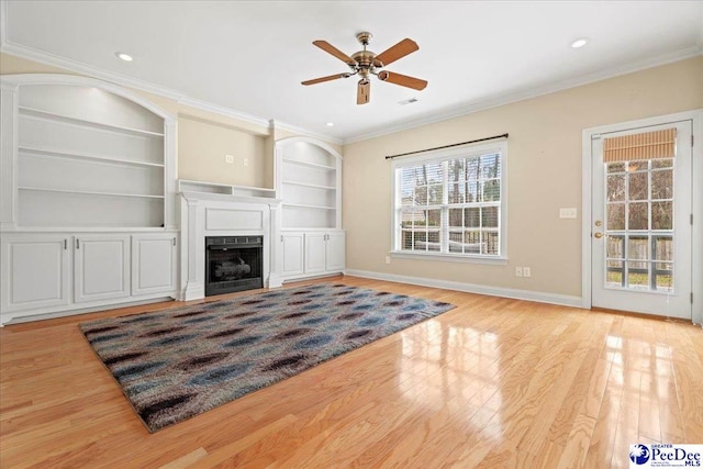 unfurnished living room with built in features, light hardwood / wood-style flooring, ornamental molding, and ceiling fan