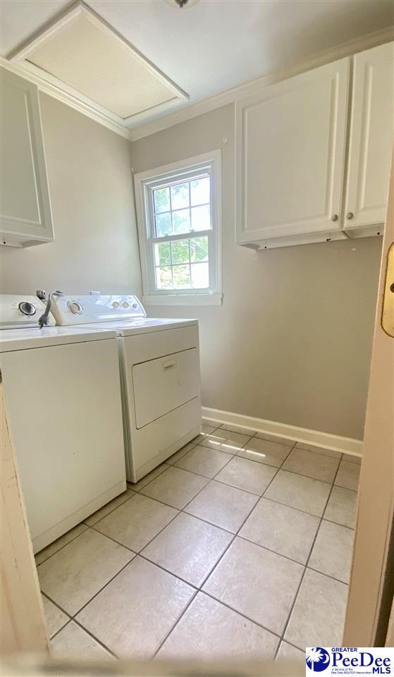 867 Congaree Dr, Florence, SC 29501 - clothes washing area featuring cabinet space, separate washer and dryer, light tile patterned floors, crown molding, and baseboards