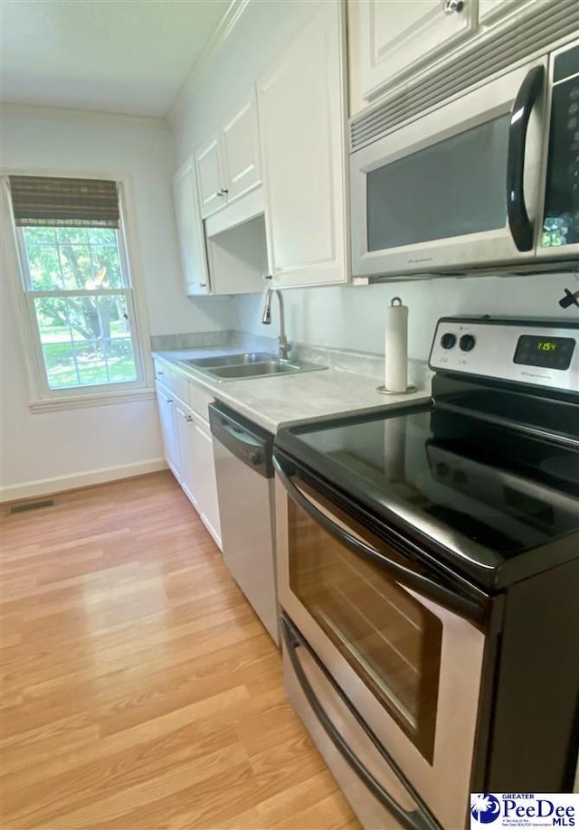 867 Congaree Dr, Florence, SC 29501 - kitchen featuring stainless steel appliances, a sink, light countertops, light wood finished floors, and white cabinets