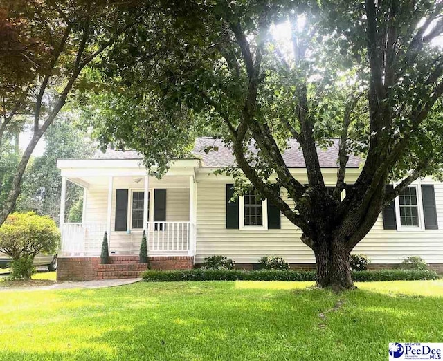 867 Congaree Dr, Florence, SC 29501 - view of front of house featuring covered porch, a front yard, and roof with shingles