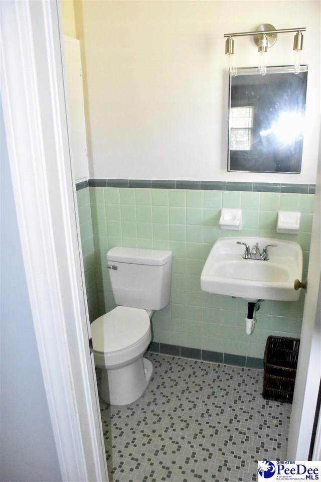 bathroom with tile walls, sink, tile patterned flooring, and toilet