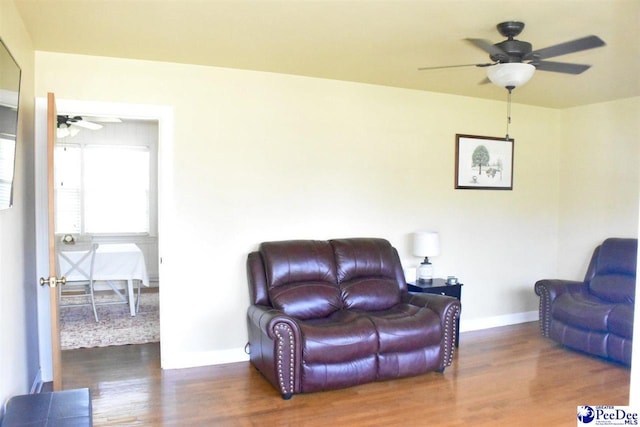 living room with dark hardwood / wood-style flooring and ceiling fan