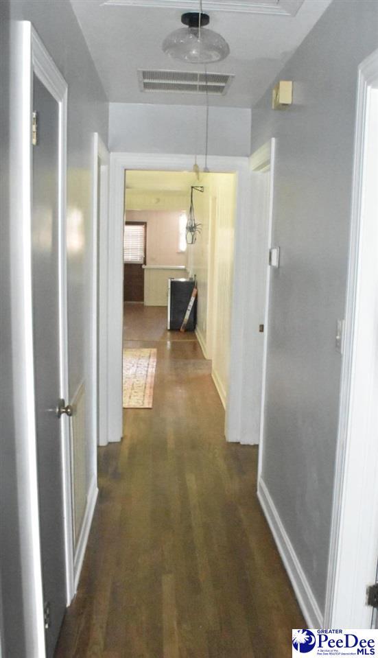 corridor with dark hardwood / wood-style flooring