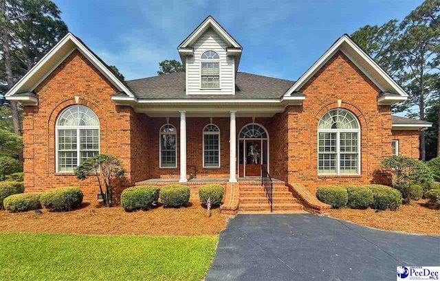 1219 Richard St, Dillon, SC 29536 - view of front of home with covered porch, brick siding, and roof with shingles
