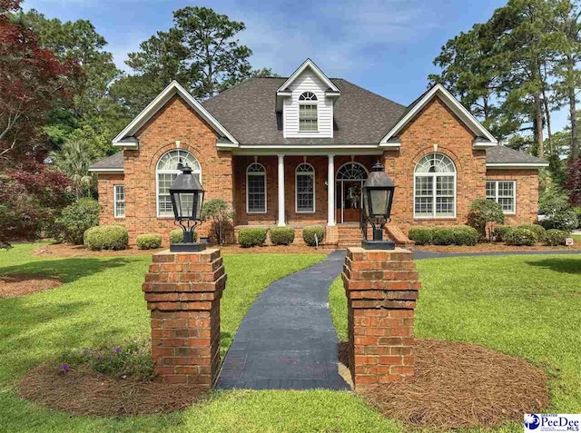 1219 Richard St, Dillon, SC 29536 - view of front facade with a shingled roof, a front yard, covered porch, and brick siding