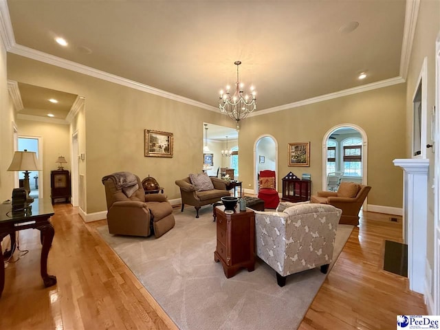 1219 Richard St, Dillon, SC 29536 - living area with arched walkways, a chandelier, light wood-type flooring, ornamental molding, and baseboards