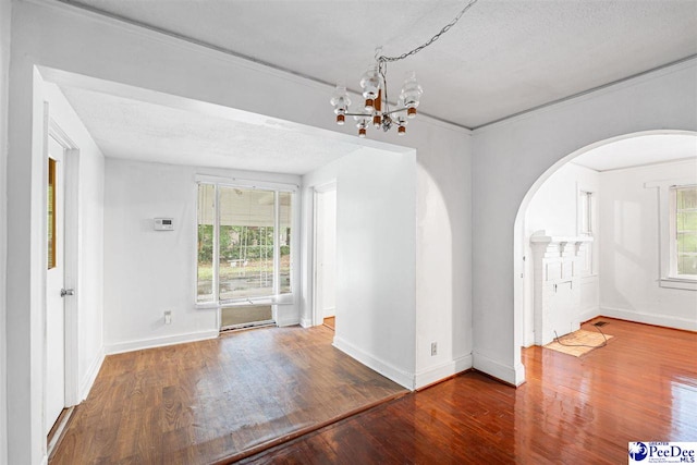 707 Chase St, Florence, SC 29501 - unfurnished dining area featuring arched walkways, a chandelier, wood finished floors, healthy amount of natural light, and a textured ceiling
