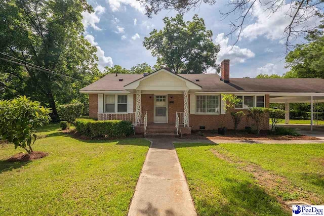 707 Chase St, Florence, SC 29501 - view of front of house featuring brick siding, a front yard, a chimney, and an attached carport