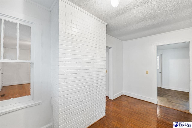 707 Chase St, Florence, SC 29501 - spare room featuring wood finished floors, a textured ceiling, brick wall, and crown molding