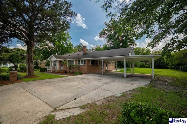 707 Chase St, Florence, SC 29501 - back of property featuring driveway, a lawn, a carport, and a chimney