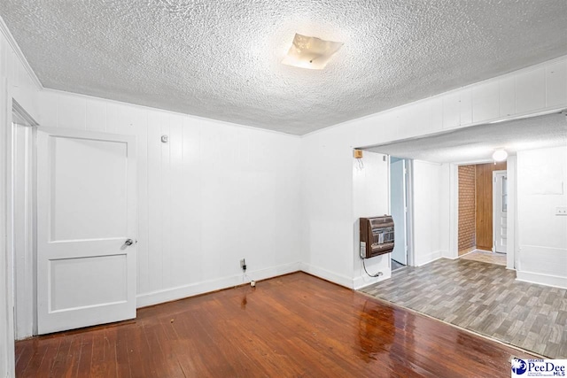 707 Chase St, Florence, SC 29501 - empty room featuring hardwood / wood-style flooring, heating unit, and a textured ceiling