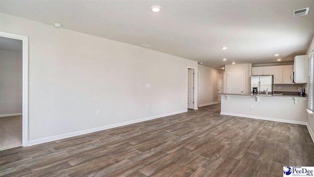 575 Strawberry Field Way, Galivants Ferry, SC 29544 - unfurnished living room featuring dark wood finished floors, baseboards, recessed lighting, and a sink