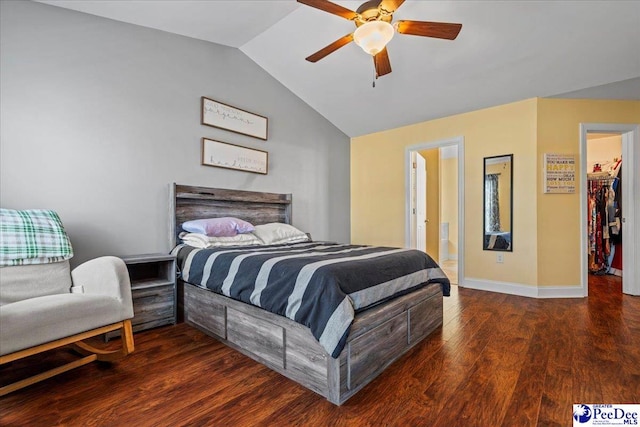 bedroom with ceiling fan, a spacious closet, vaulted ceiling, and dark hardwood / wood-style flooring