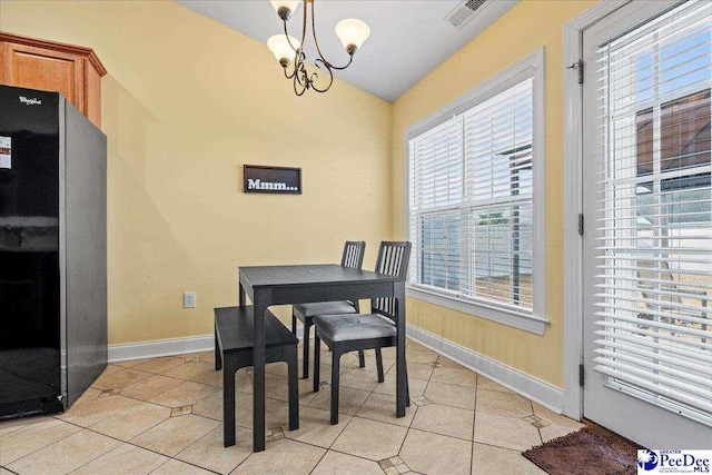 dining area with light tile patterned flooring, vaulted ceiling, and a notable chandelier