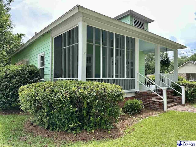 101 W Baptist St, Marion, SC 29571 - view of home's exterior with a sunroom, a lawn, and stairway