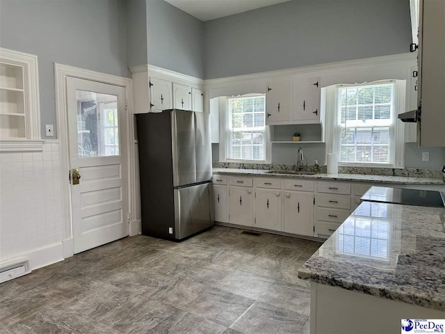101 W Baptist St, Marion, SC 29571 - kitchen with freestanding refrigerator, white cabinets, open shelves, and light stone countertops