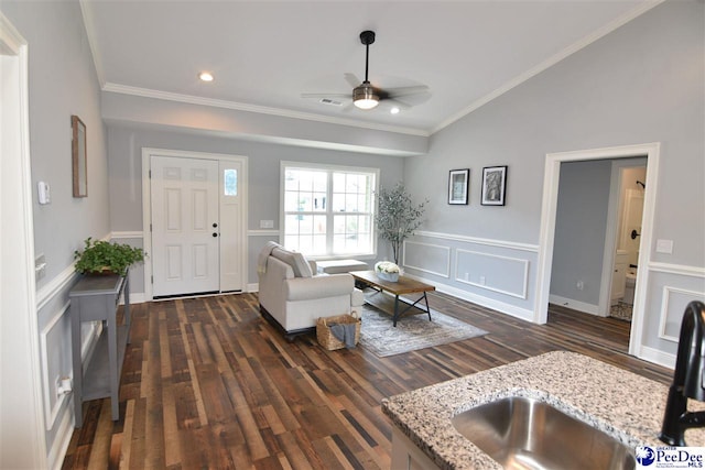 living room featuring lofted ceiling, sink, crown molding, and dark hardwood / wood-style floors