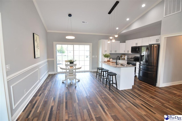 kitchen with a breakfast bar area, decorative light fixtures, electric range, stainless steel fridge, and white cabinets