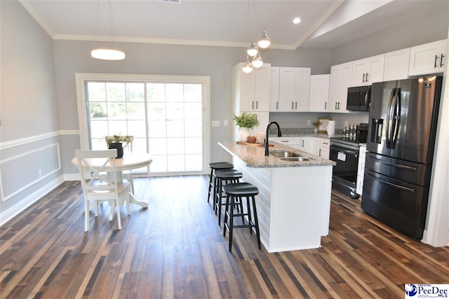 kitchen with pendant lighting, white cabinets, electric range, stainless steel refrigerator with ice dispenser, and light stone countertops