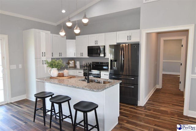 kitchen with crown molding, a breakfast bar, appliances with stainless steel finishes, white cabinetry, and light stone counters