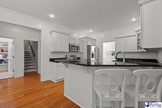 1642 Jefferson Dr, Florence, SC 29501 - kitchen with appliances with stainless steel finishes, a sink, a peninsula, crown molding, and a kitchen bar