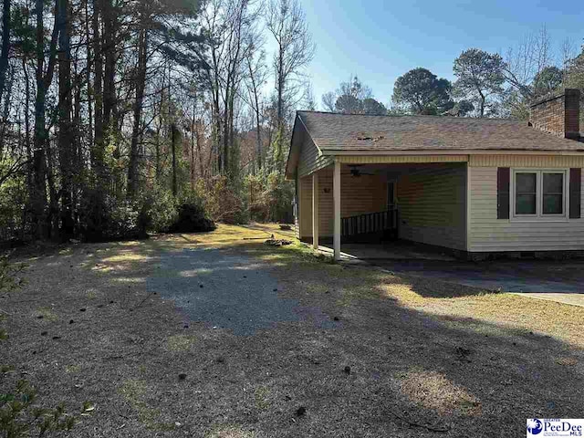 view of side of home with a shingled roof and a chimney