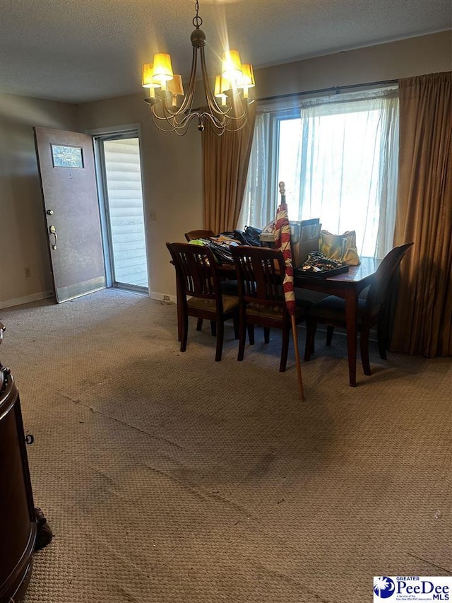 carpeted dining space featuring a textured ceiling, baseboards, and an inviting chandelier