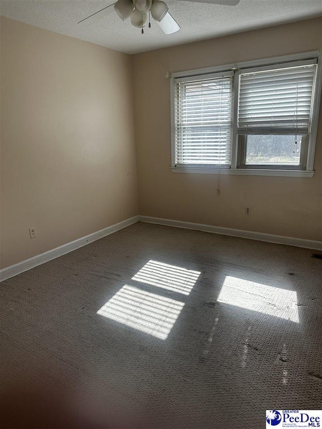 spare room featuring carpet flooring, ceiling fan, a textured ceiling, and baseboards