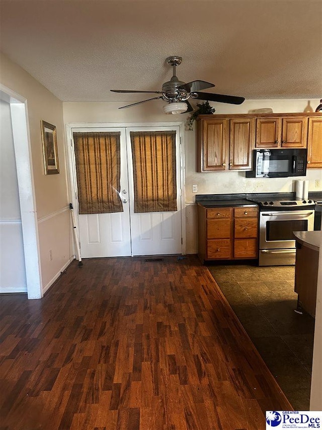 kitchen with electric stove, dark countertops, dark wood-style floors, brown cabinets, and black microwave