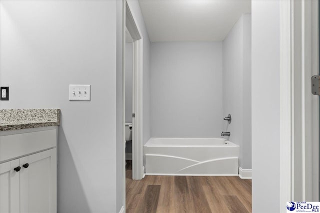 3324 Spiral Ln, Effingham, SC 29541 - full bath featuring toilet, wood finished floors, a bathing tub, baseboards, and vanity