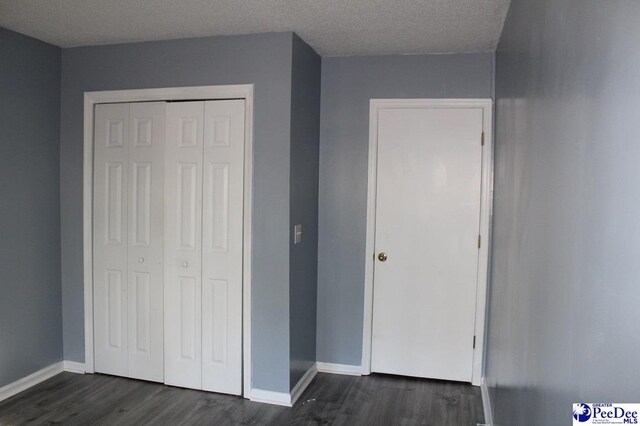 3028 Trent Dr, Florence, SC 29505 - unfurnished bedroom with dark wood-type flooring, a textured ceiling, and a closet