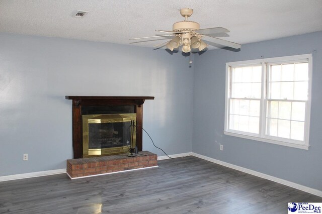 3028 Trent Dr, Florence, SC 29505 - unfurnished living room with dark hardwood / wood-style flooring, a brick fireplace, a textured ceiling, and ceiling fan