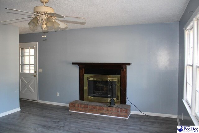 3028 Trent Dr, Florence, SC 29505 - unfurnished living room featuring dark wood-type flooring, a brick fireplace, and a wealth of natural light