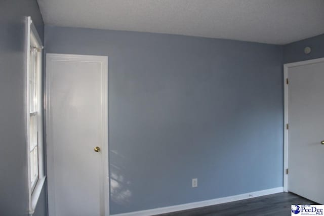3028 Trent Dr, Florence, SC 29505 - unfurnished room with dark wood-type flooring, a textured ceiling, and plenty of natural light