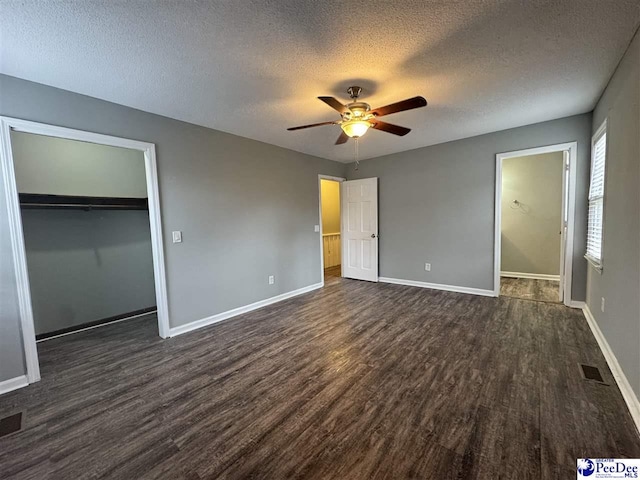 unfurnished bedroom with ceiling fan, a closet, dark hardwood / wood-style flooring, and a textured ceiling