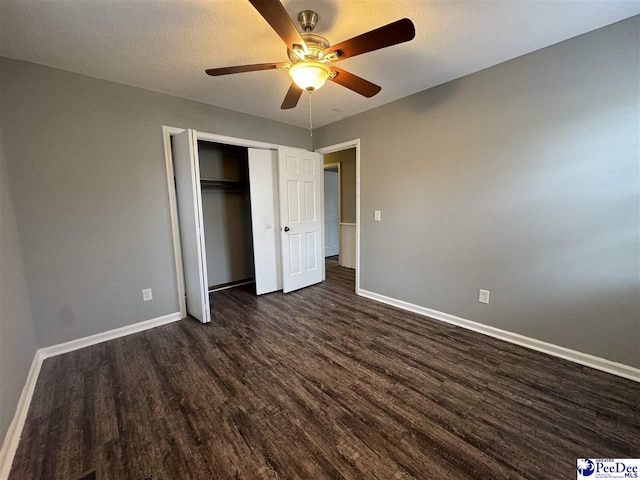 unfurnished bedroom featuring a textured ceiling, dark wood-type flooring, a closet, and ceiling fan