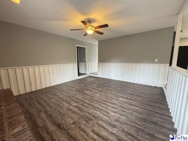 spare room featuring ceiling fan, dark hardwood / wood-style floors, and a textured ceiling