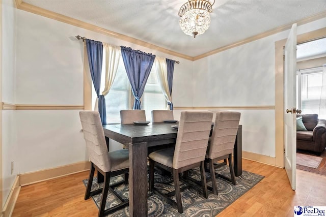 427 Marlboro Ave, Hartsville, SC 29550 - dining area with crown molding, a chandelier, a textured ceiling, and light hardwood / wood-style floors