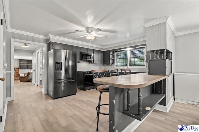 821 W Shirley Rd, Pamplico, SC 29583 - kitchen with stainless steel appliances, ceiling fan, light wood finished floors, dark cabinetry, and crown molding