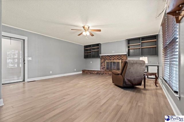 821 W Shirley Rd, Pamplico, SC 29583 - unfurnished living room featuring a ceiling fan, a textured ceiling, light wood finished floors, crown molding, and healthy amount of natural light