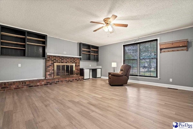 821 W Shirley Rd, Pamplico, SC 29583 - unfurnished living room with wood finished floors, a ceiling fan, a textured ceiling, a fireplace, and baseboards