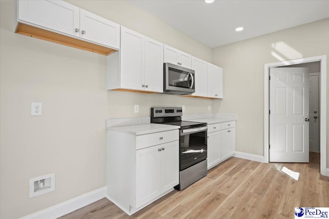 kitchen featuring stainless steel appliances, white cabinetry, and light wood-type flooring