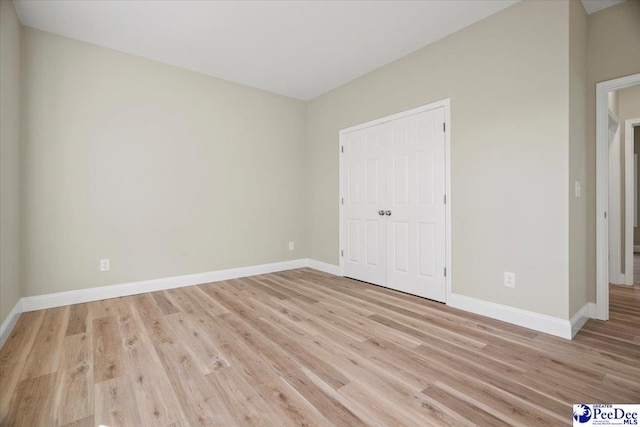 unfurnished bedroom featuring a closet and light wood-type flooring