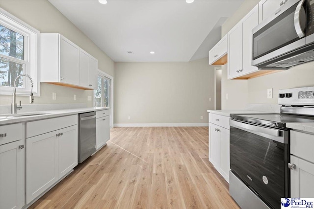 kitchen featuring white cabinetry, stainless steel appliances, light hardwood / wood-style floors, and sink