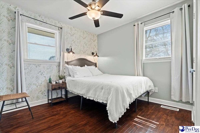 bedroom with visible vents, wallpapered walls, baseboards, and wood finished floors