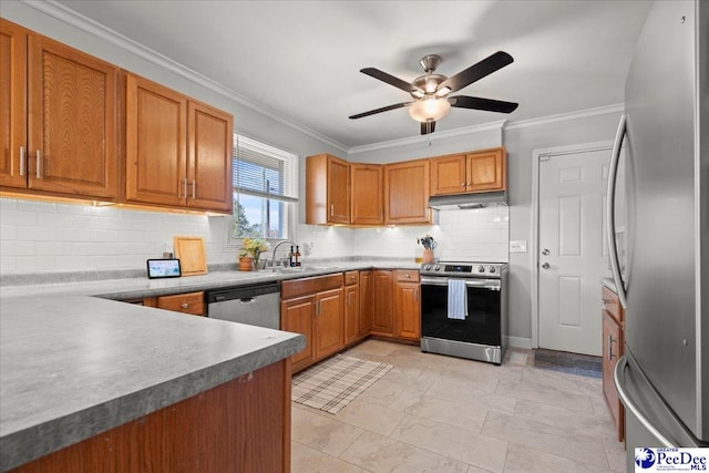 kitchen featuring a sink, under cabinet range hood, backsplash, stainless steel appliances, and crown molding