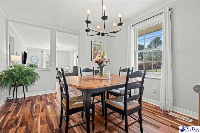 dining room with wood finished floors, visible vents, and ornamental molding