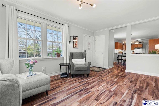 sitting room with crown molding, baseboards, and wood finished floors