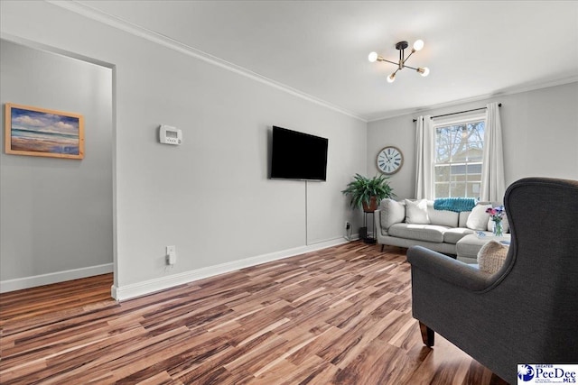 living room with baseboards, wood finished floors, a notable chandelier, and ornamental molding