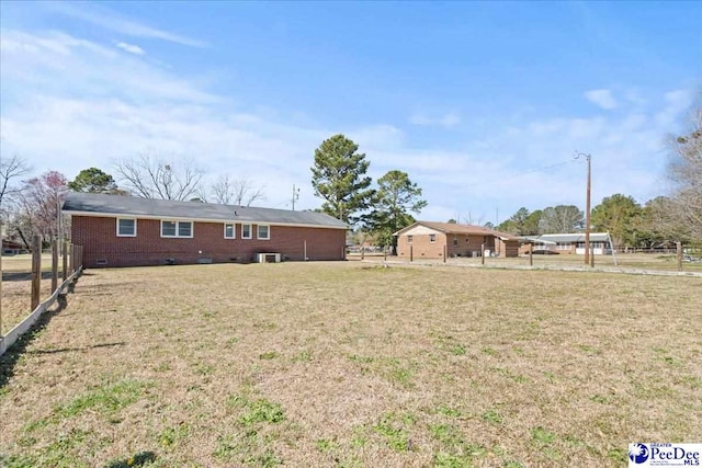 view of yard with central AC and fence